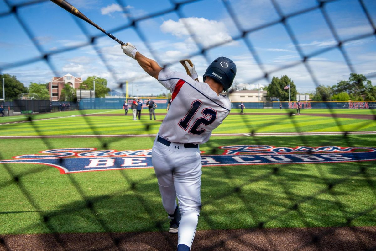 Outfielder Zane Bennett warms up near the dugout right before the game against American River College at Santa Rosas Cook Sypher Field on Thursday, April 25, 2024.