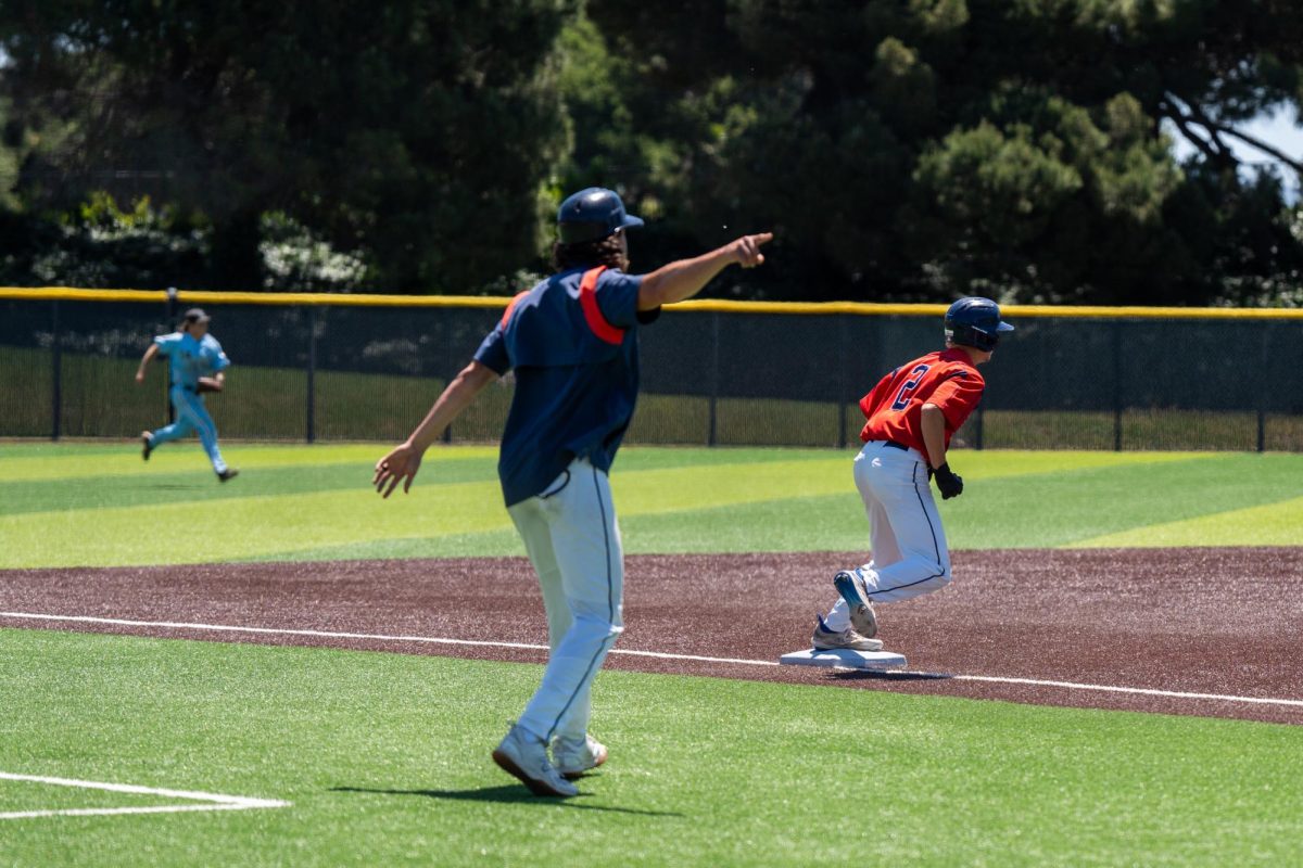 Third base coach Jeff Bart sends right fielder Quinn Medin home after an error on a double play attempt at second against Cabrillo College in the first round of the CCCAA Super Regionals in Hayward on Thursday, May 9, 2024.