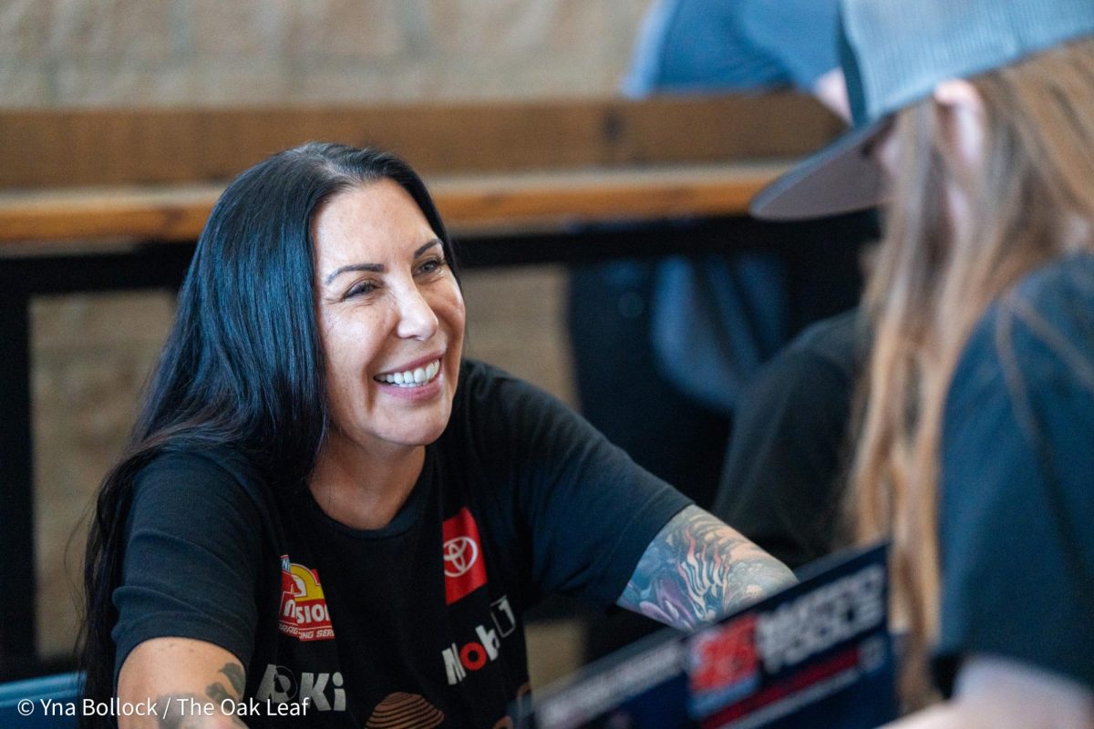 Funny Car driver Alexis DeJoria autographs a sign for a fan at the DENSO NHRA Sonoma Nationals on Friday, July 26, 2024 in Sonoma.