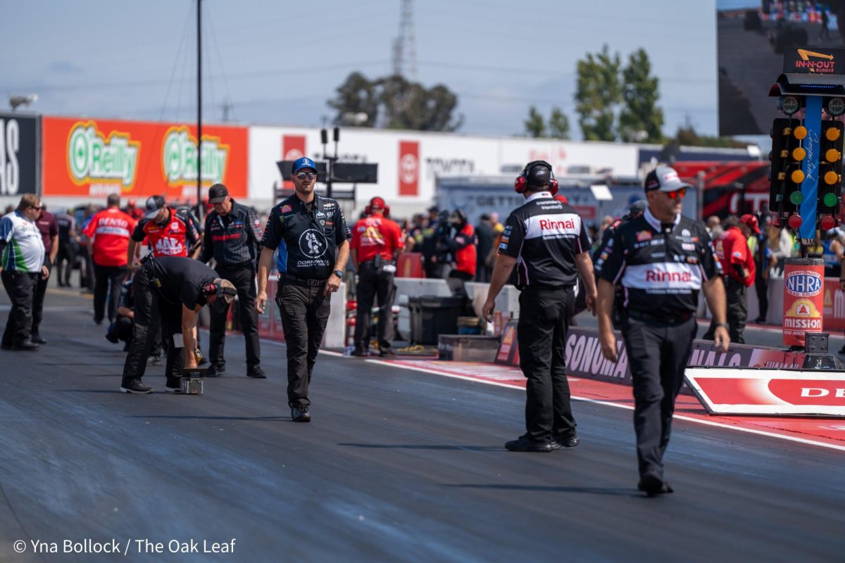 Various members of the pit crew assess the track for the next Top Fuel qualifying round at the DENSO NHRA Sonoma Nationals on Saturday, July 27, 2024 in Sonoma.