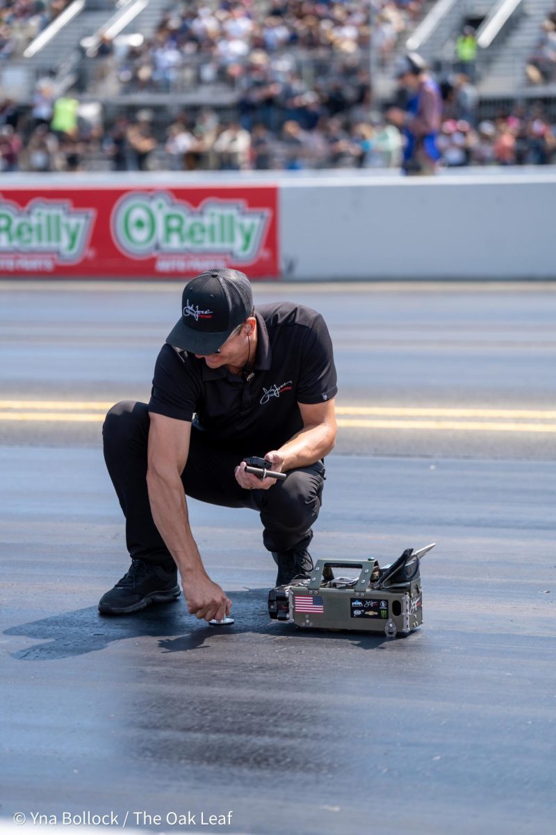 A member of the John Force Racing team assesses the track with a traction measuring device ahead of the next Top Fuel qualifying round at the DENSO NHRA Sonoma Nationals on Saturday, July 27, 2024 in Sonoma.