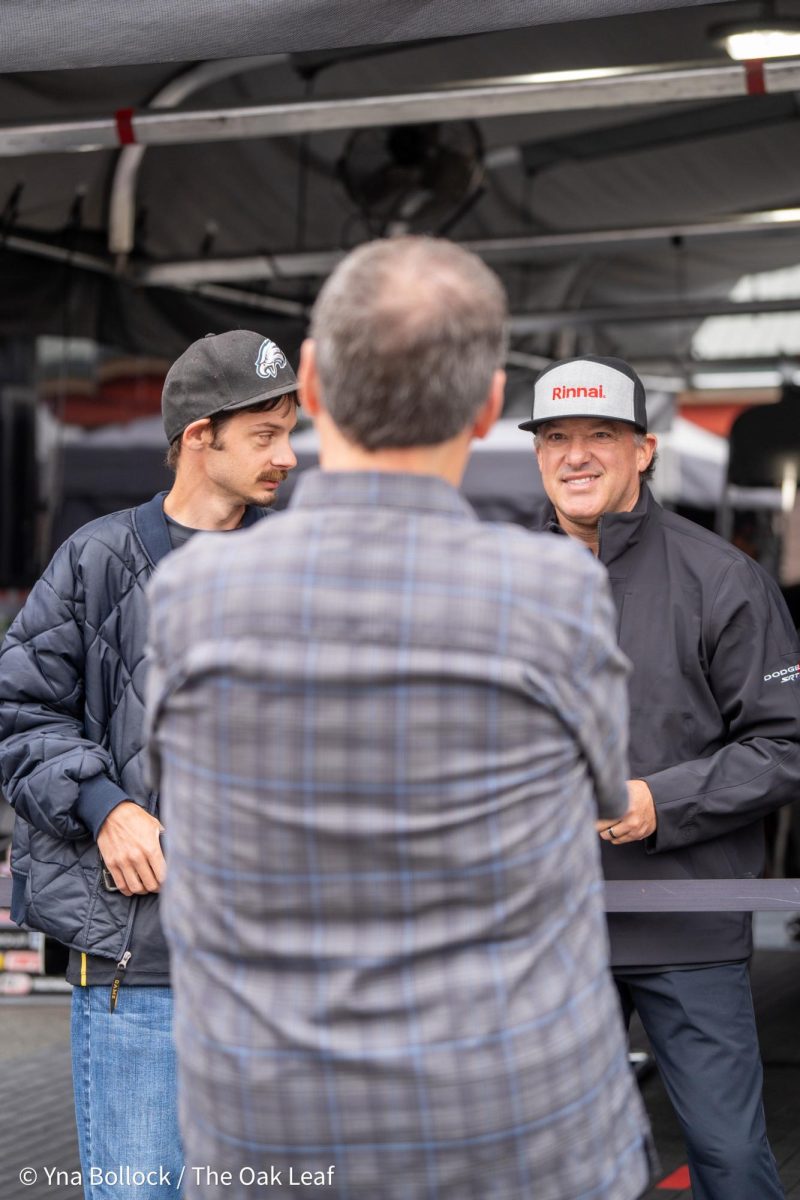 Funny Car driver Tony "Smoke" Stewart interacts with a couple of fans during an autograph session at the DENSO NHRA Sonoma Nationals on Saturday, July 27, 2024 in Sonoma. 