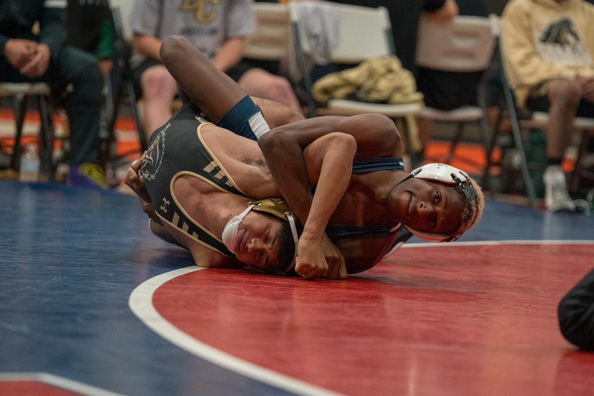 Derek Ruffin stretches the Delta College wrestler's arm above his head during a match in Haehl Pavilion on September 14, 2024.