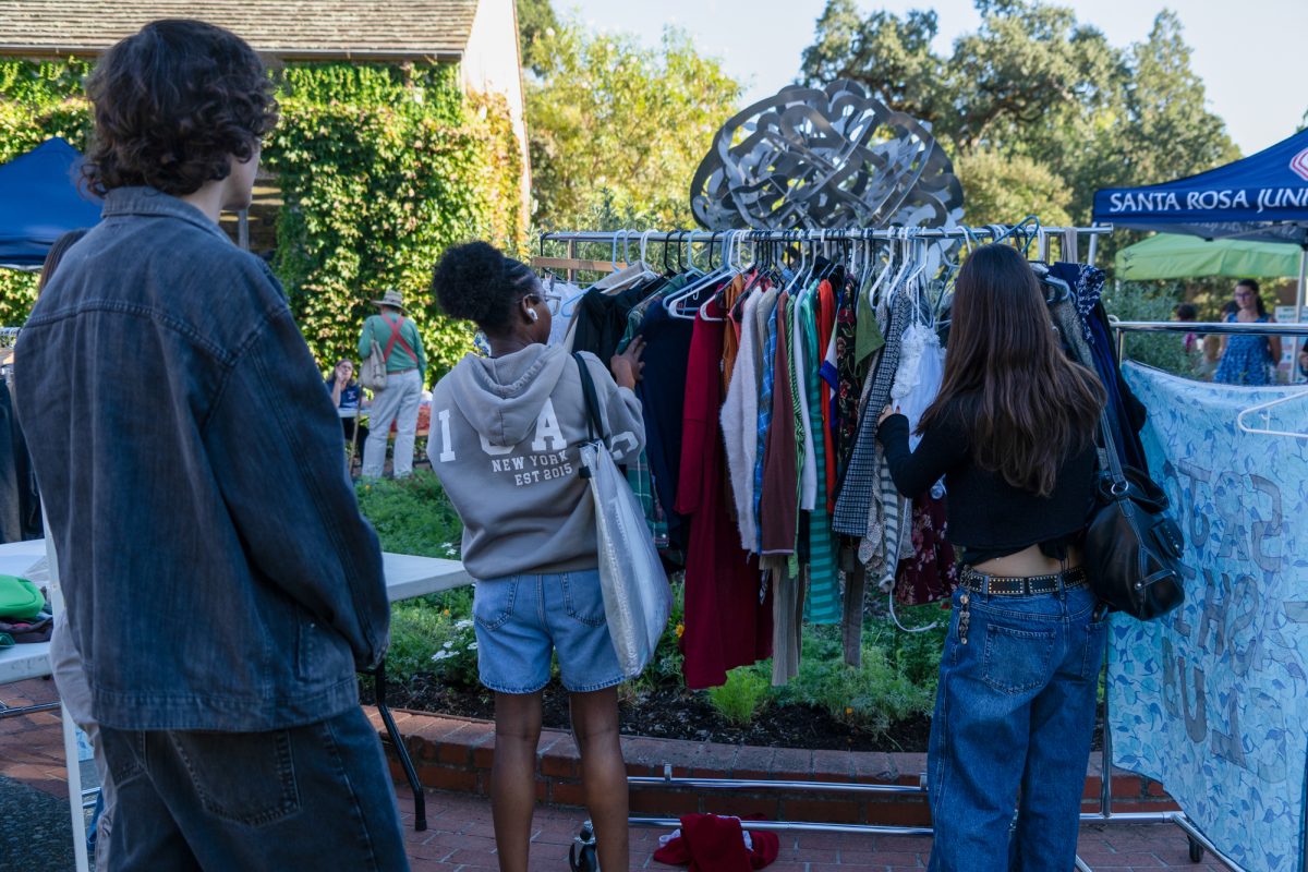 Students pick out clothes at the Fashion Club's free clothing swap booth at the Green Living Fair in the Bertolini Quad on the Santa Rosa campus on Thursday, Oct. 10, 2024.