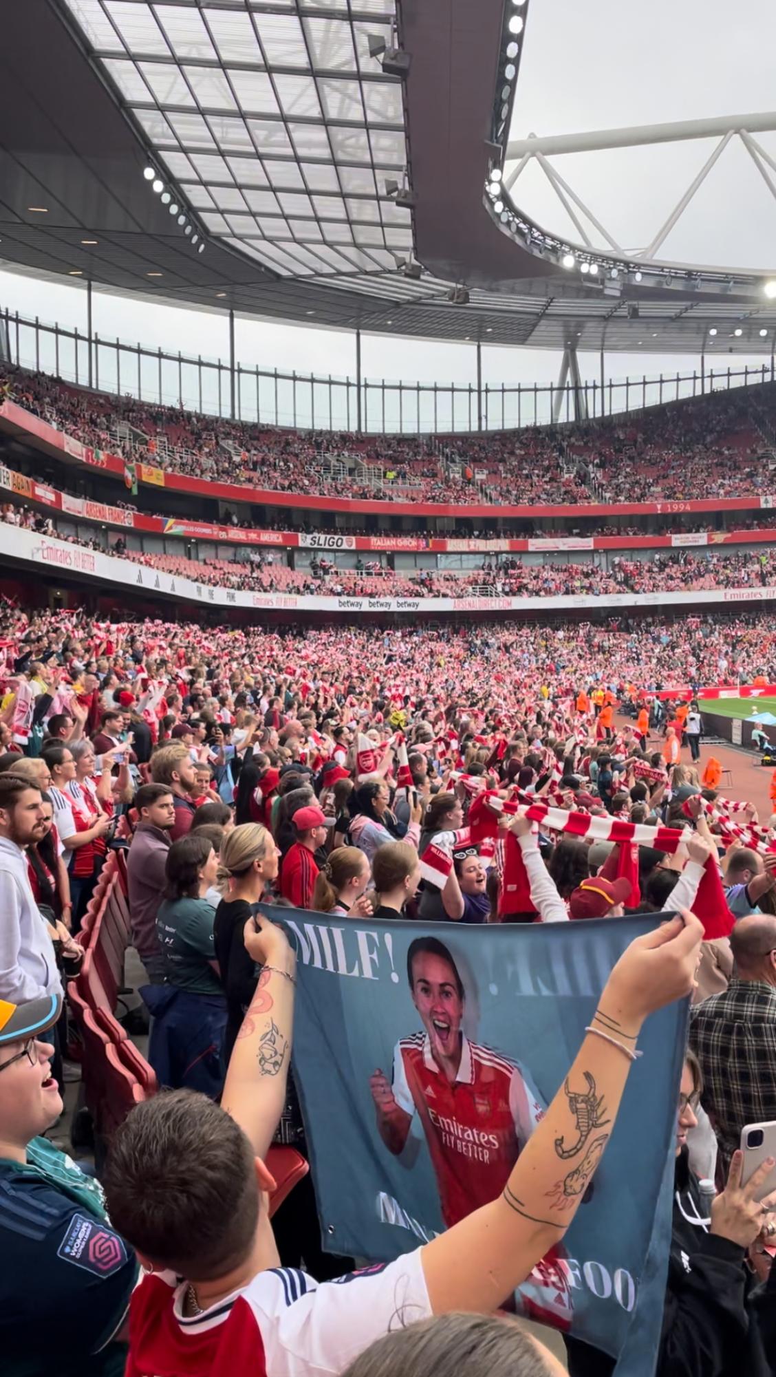 A raucous crowd at Emirates Stadium cheers on the Arsenal Women's team, singing the fight song "North London Forever." The game ended in a tie with Manchester City, who came in second place in the Women's Super League (WSL) last year. Arsenal came in third place.