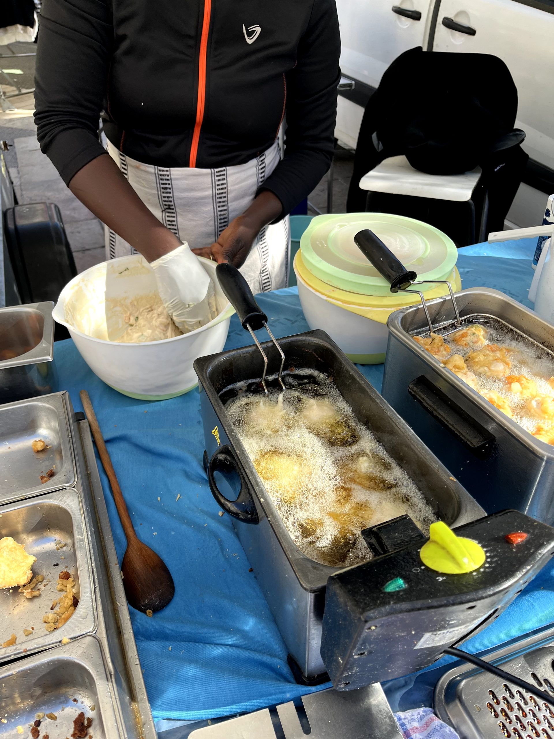 A Senegalese farmers’ market purveyor molds balls of batter and dips them into a bubbling tub of oil to form delicious pumpkin caribbean fritters. These accras reflect the high quality of food found throughout the local French market.