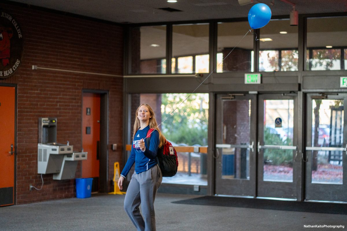 Bear Cubs’ middle blocker Sarah Thornton walks around with an SRJC-colored balloon at Haehl Pavilion before their game against San Joaquin Delta on Friday, Nov. 15, 2024