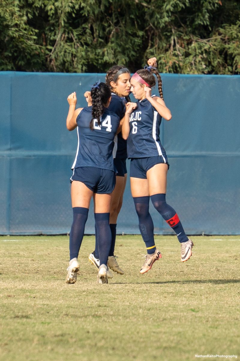 Bear Cubs’ midfielders Ashley Vigil, Natalie Ortiz, and Olivia Hohnstein shoulder bump before the second half against Skyline College at home on Nov. 23, 2024