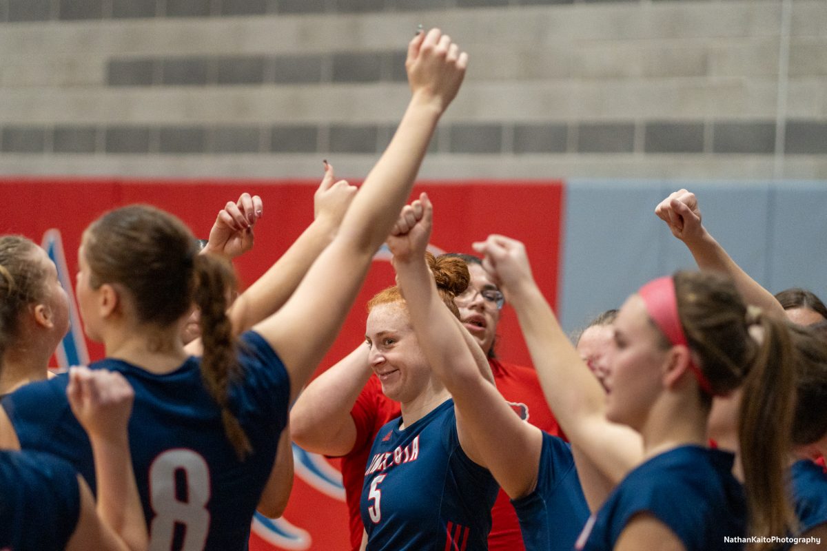 Bear Cubs’ outside hitter Tessa Taylor and the rest of the team raise their fists to rally together against American River at the American River gym on Wednesday, Nov. 26. 