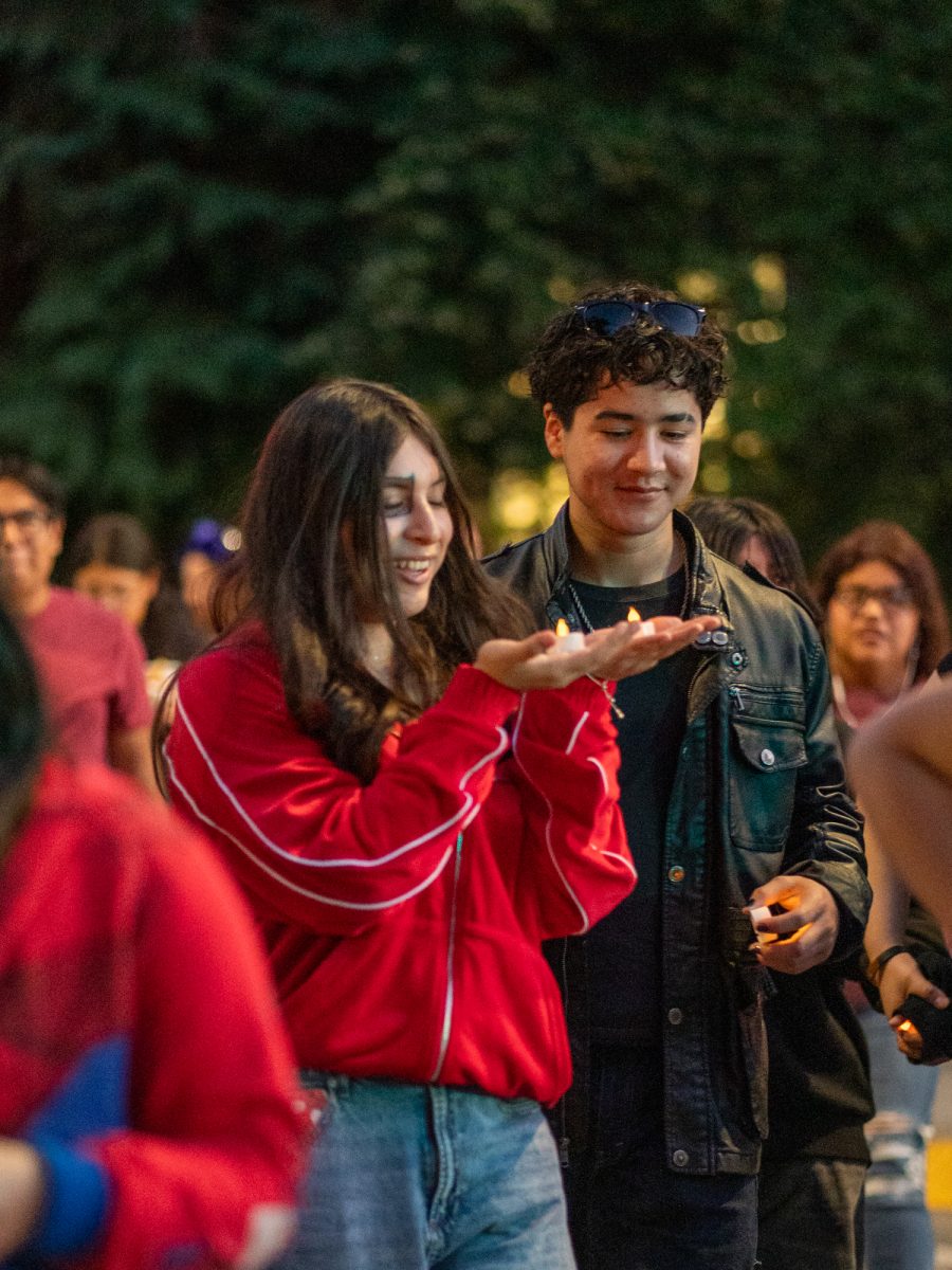 Attendees carry non-flammable candles on their way to Newman Auditorium to view the first of many ofrendas during the Dia De Muertos celebration at the Santa Rosa campus on Wednesday, Oct. 23, 2024.