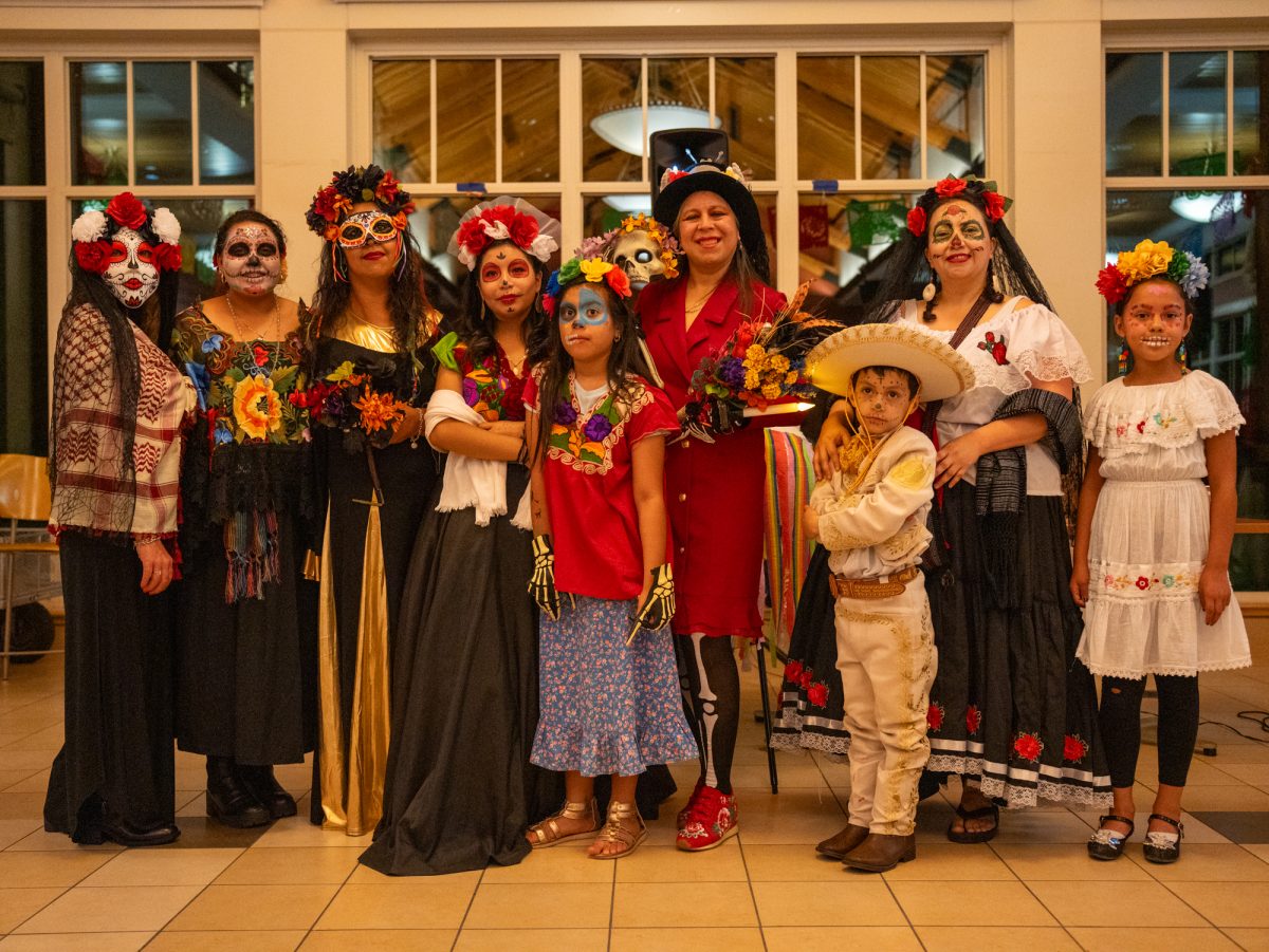 Attendees pose for a photo after the Catrin/Catrina contest held during the Dia De Muertos celebration at the Bertolini Student Center on Wednesday, Oct. 23, 2024.