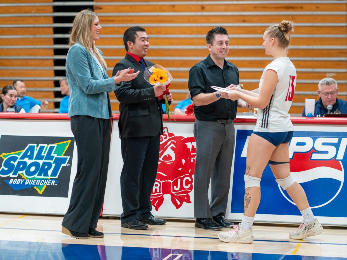 Assistant coach Ryan Hughes, middle right, recognizes middle blocker Sarah Thornton, right, ahead of Sophomore Night at home against San Joaquin Delta on Friday, Nov. 15, 2024.