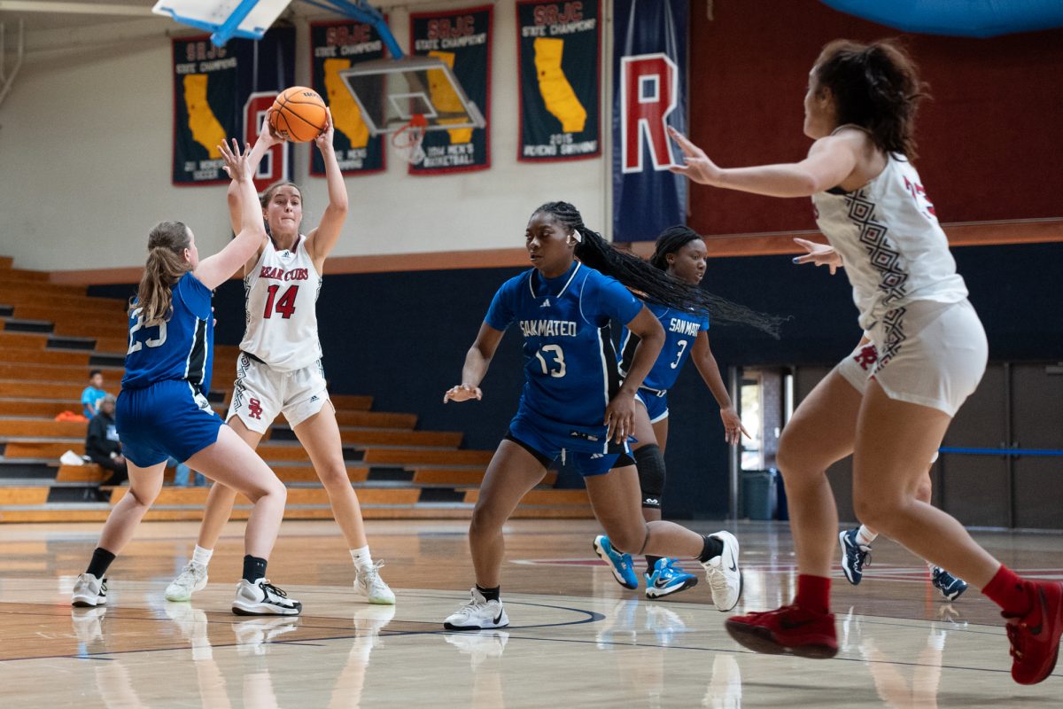 Bear Cubs forward Kaia Eubanks, left, attempts an overhead pass to guard/forward Ivy Gonzalez, right, during the game against College of San Mateo at Haehl Pavilion on Friday, Dec. 6, 2024.