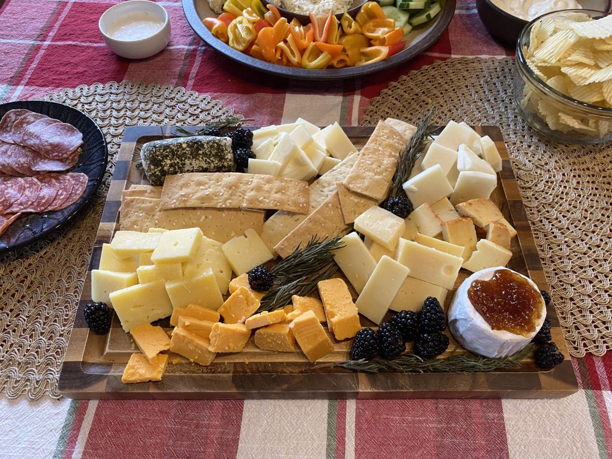 A board among a holiday spread with locally sourced cheeses, salami, blackberries, and rosemary. The produce is sourced from the Marin French Cheese Company and Oliver's Market in Cotati, CA on Dec. 25, 2023.