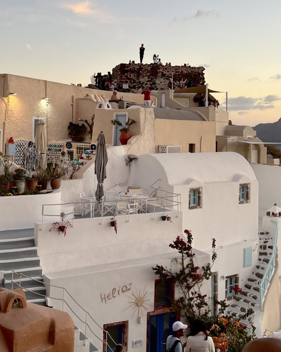 Locals gather in the hillside town of Oia, Santorini to view the sunset. 