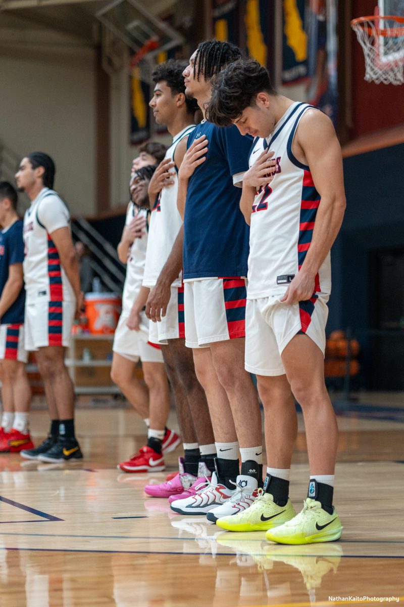 The Bear Cubs stand in silence, hands on hearts as the national anthem rings around Haehl Pavilion on Tuesday, Jan. 14, 2025