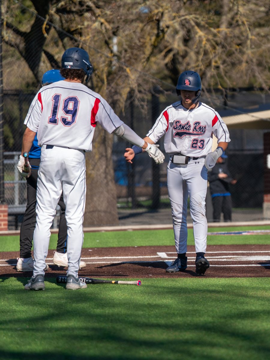 Santa Rosa third baseman Caze Derammelaere greets right fielder Cooper Wood at the plate after a single from catcher Cameron Duran brings him home in the bottom of the third at home against Modesto on Tuesday, Feb. 25, 2025.