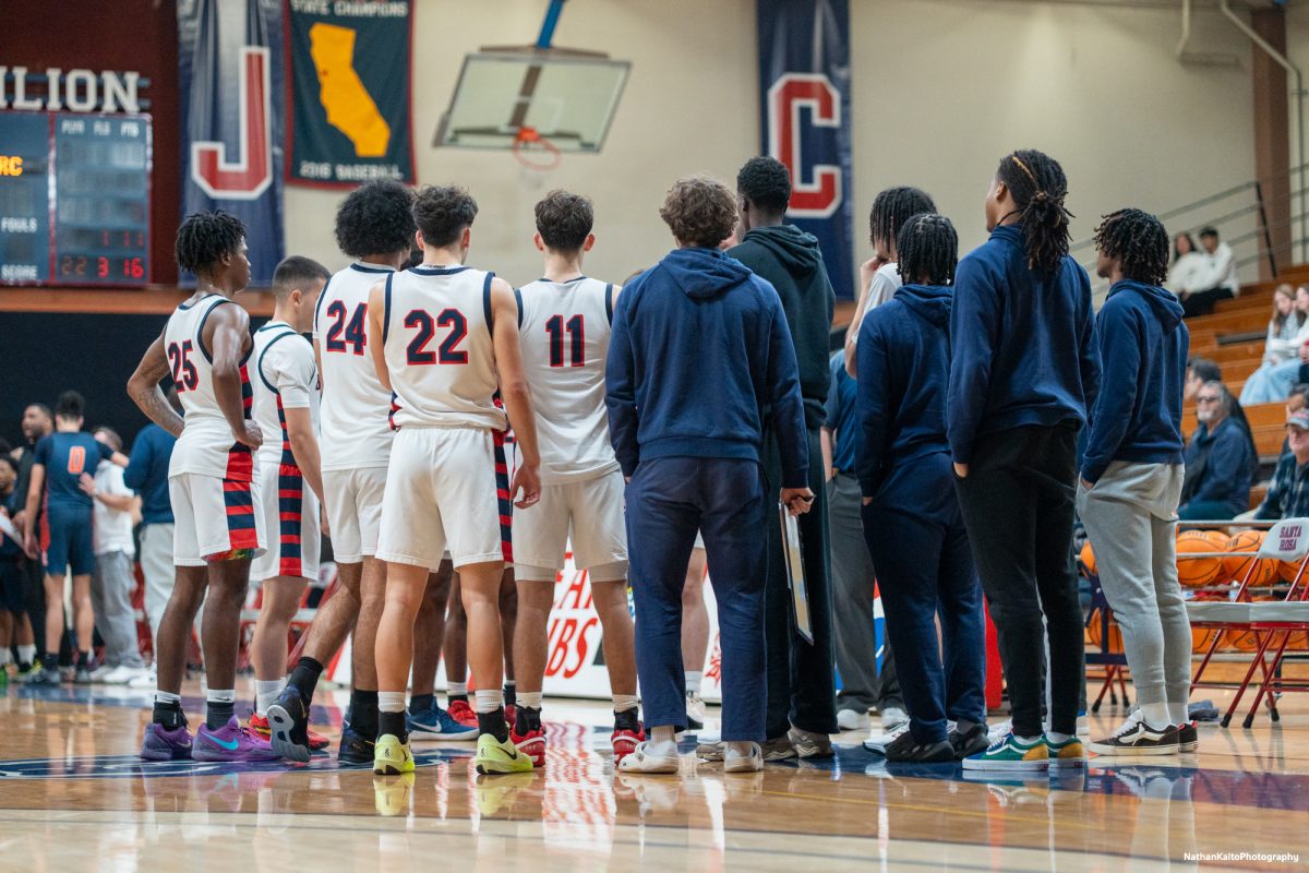 The Bear Cubs huddle around head coach Craig McMillian during a timeout against Cosumnes River at Haehl Pavilion on Friday, Feb. 7, 2025.