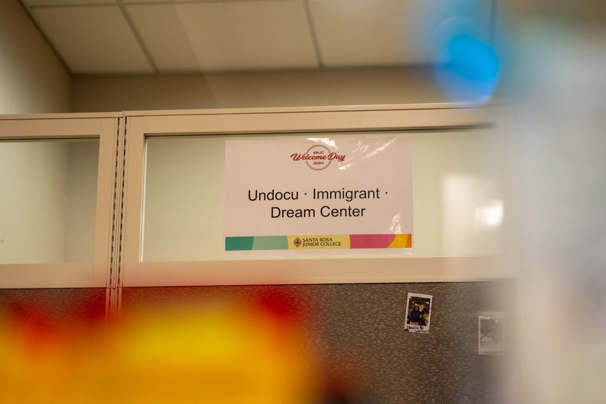 A sign from SRJC's Welcome Day 2024 advertising the Dream Center sits above the staff desk near the entrance of 4832 Bertolini Hall. 