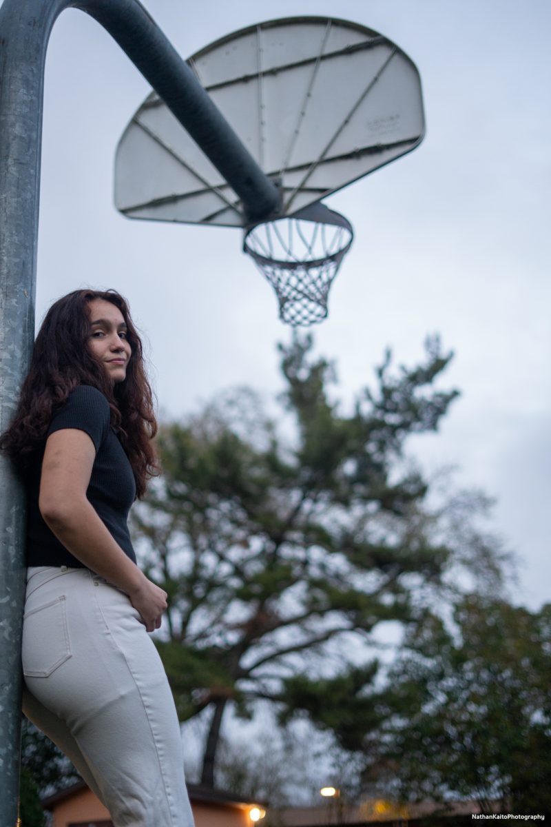 Bear Cubs' sophomore guard Ivy Gonzalez leans back against a basketball hoop outside of Polly O'Meara Hall on Monday, Feb. 24, 2025.