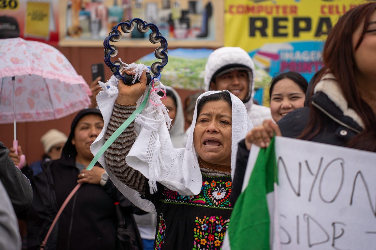 An older adult stands in protest of the crackdown on immigration outside of Mitote Food Park on Monday, Feb. 3, 2025.