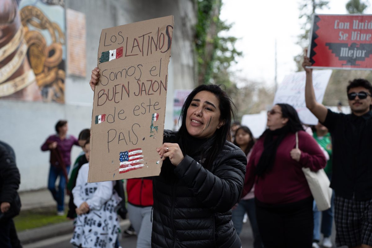 A protester pickets the crackdown on immigration while marching down Olive Street on Monday, Feb. 3, 2025.