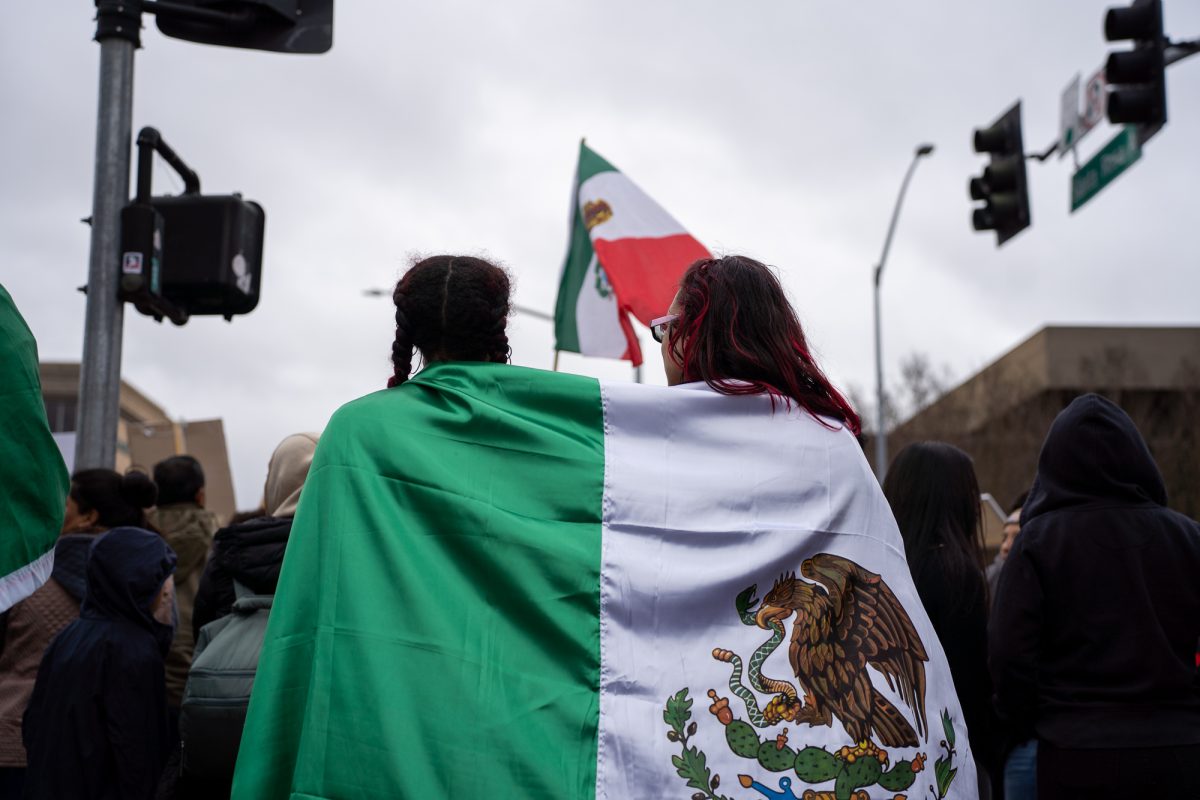 Two protesters wrapped in a Mexican flag stand against the crackdown on immigration at Old Courthouse Square on Monday, Feb. 3, 2025.