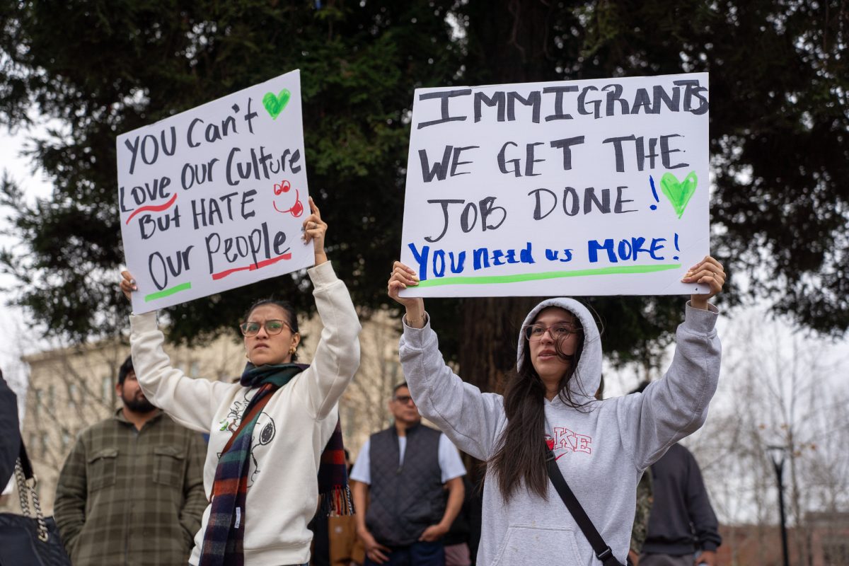 Ashley, left, and Dayren, right, stand in protest of immigration crackdowns at Old Courthouse Square on Monday, Feb. 3, 2025.