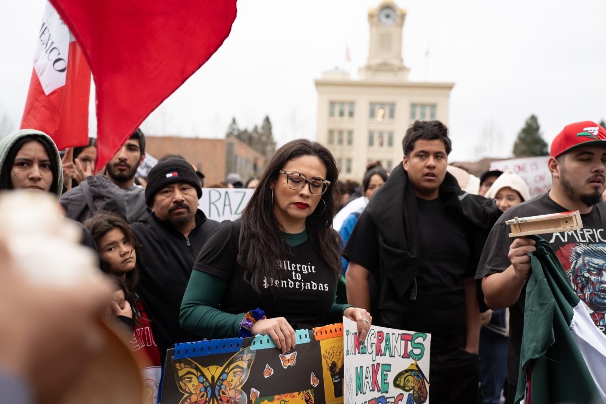 A protestor with a solemn face stands amidst the crowd during a protest against immigration crackdowns at Old Courthouse Square on Monday, Feb. 3, 2025.