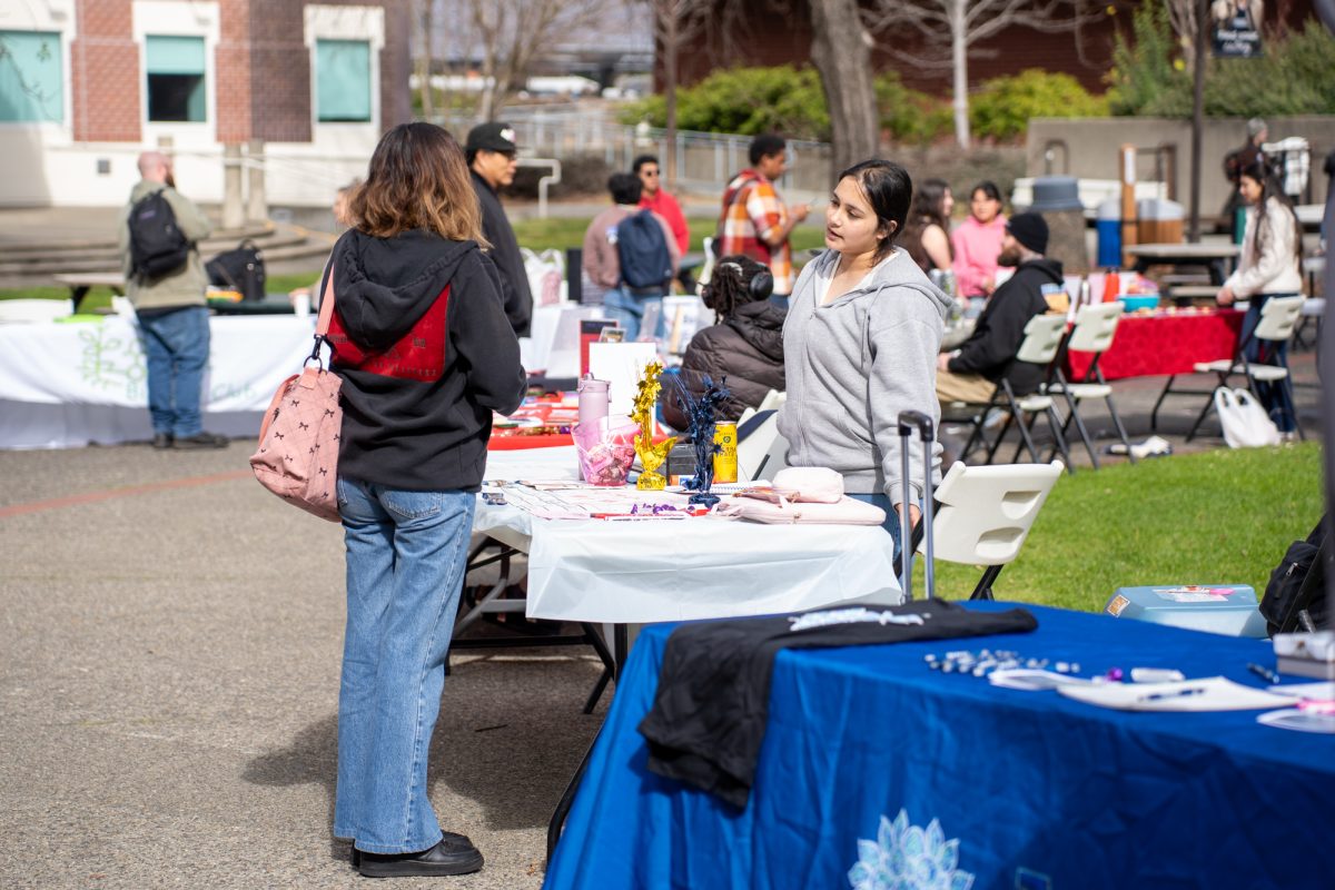 Two SRJC students converse at the financial aid fun fair outside of Plover Hall on Wednesday, Feb. 12, 2025.