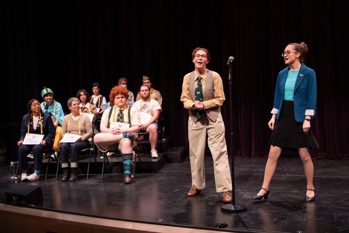 Lizzy Bies as Vice Principal Panch (center) cracks a joke as the Spelling Bee is about to begin.