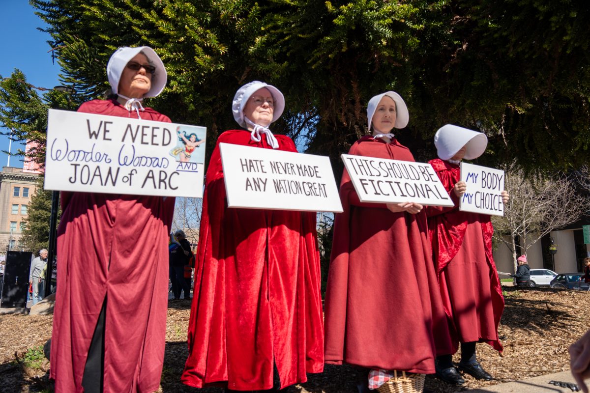 Demonstrators share their feelings on International Women’s Day wearing the chilling red cloak and white bonnet as described in Margaret Atwood’s The Handmaid’s Tale during the International Women’s Day march in Old Courthouse Square on Saturday, March 8, 2025 in Santa Rosa.  