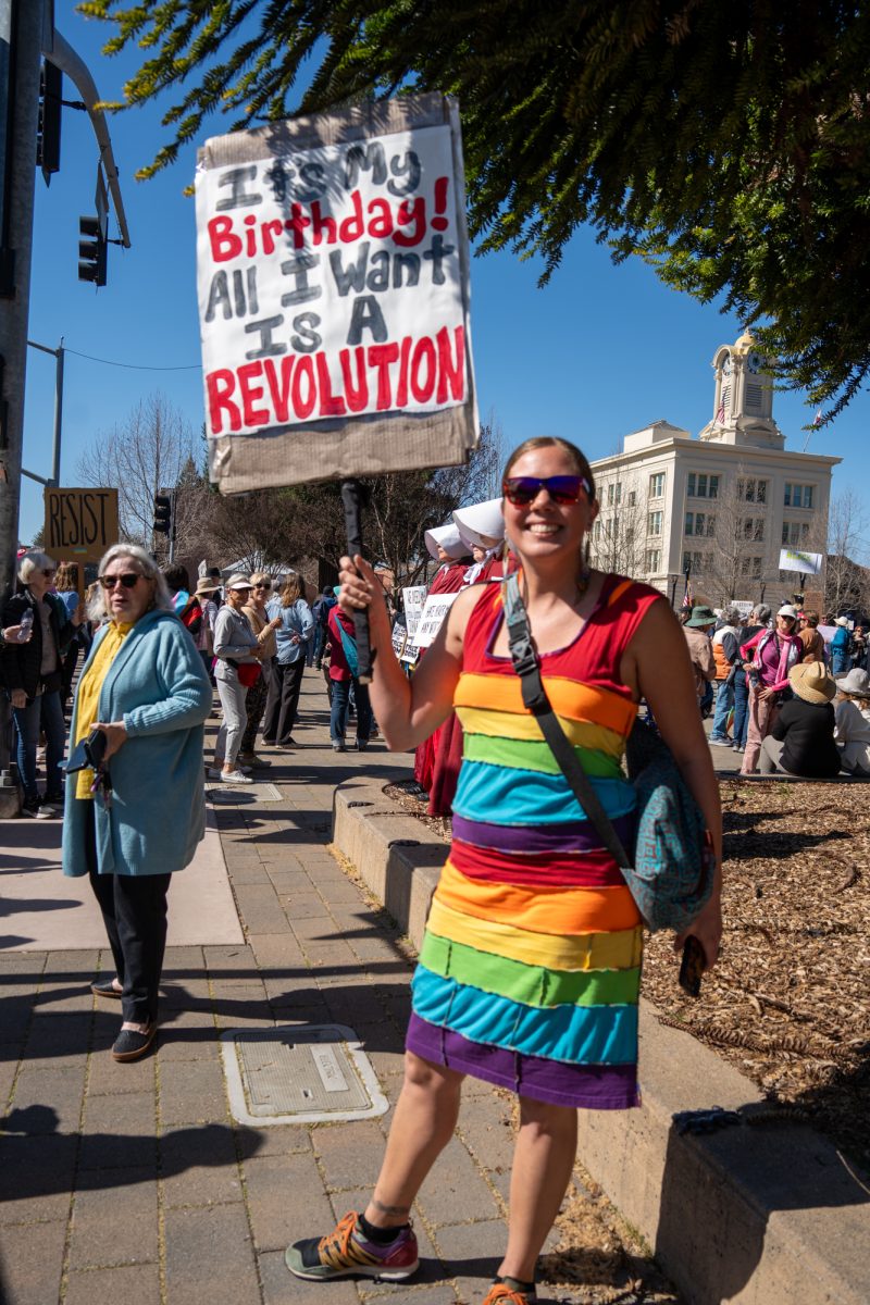 A demonstrator celebrating their birthday holds up a hand painted sign during the International Women’s Day march in Old Courthouse Square on Saturday, March 8, 2025 in Santa Rosa.  