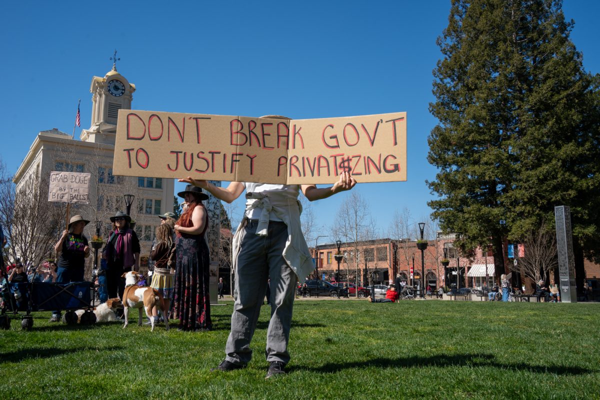 A handwritten sign on cardboard is held up by a demonstrator during the International Women’s Day march in Old Courthouse Square on Saturday, March 8, 2025 in Santa Rosa.  