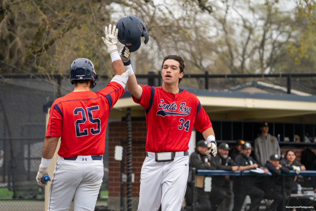 Santa Rosa Junior College's designated hitter J.T. Summers lifts his helmet and celebrates with teammate Josh Martin after hitting a homerun and scoring a run against San Joaquin Delta on Saturday, March 15, 2025 in Santa Rosa.